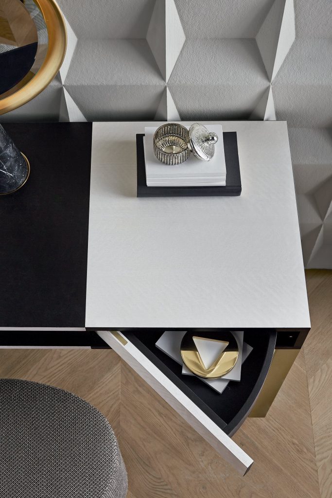 Selene : Closeup of a rectangular desk in white and black with drawers in a room.