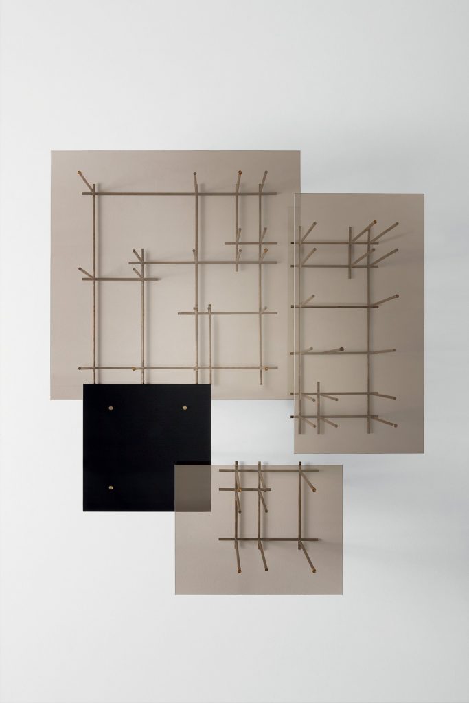 Tetris: three rectangle glass-top coffee tables with bronze metal frame and cubic shapes on a white background.