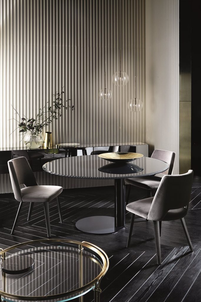 Thea: Two gray chairs with a curved backrest and four black legs in a living room.