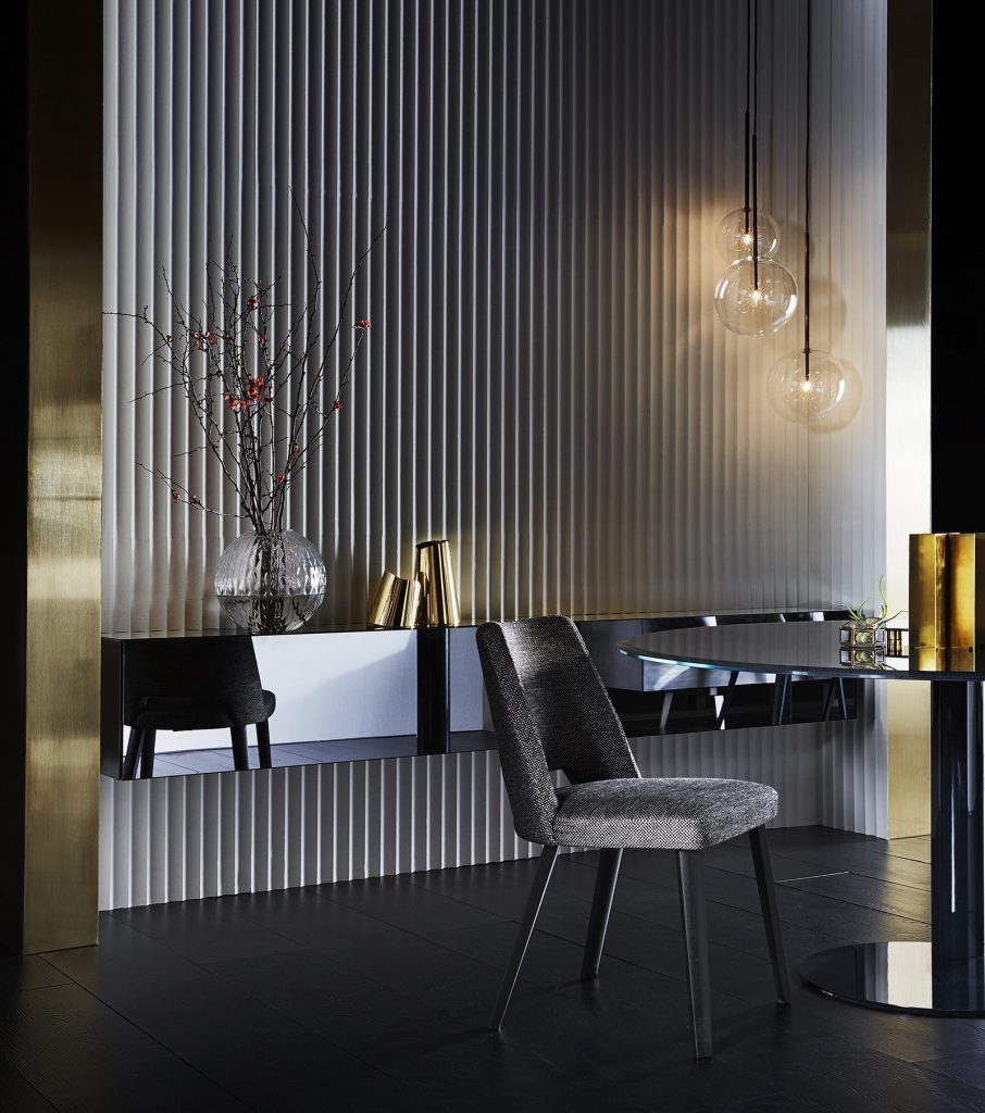Thea: A gray chair with a curved backrest and four black legs in a living room.