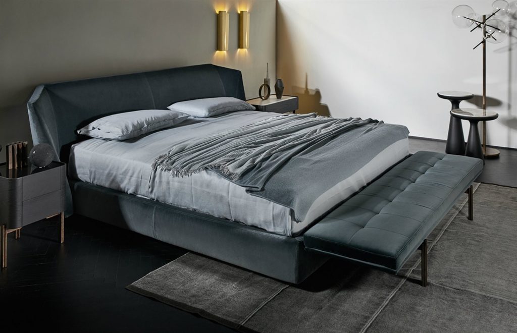 Twelve bedside table. Top in square shape in white cracket, black drawers and brown legs in a bedroom.