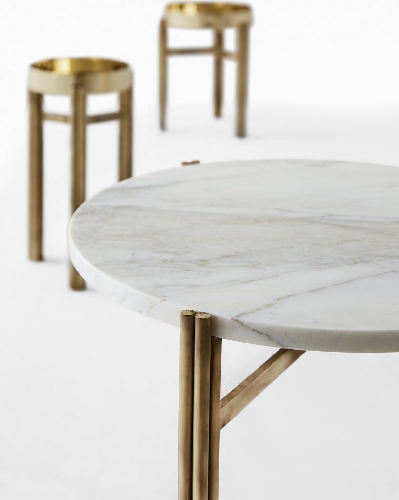 Three Twelve coffee tables. Two golden round tops and one in round marble with three bronze legs on a white background.