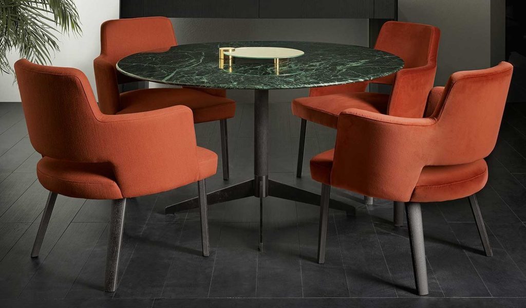 Zen Black table, round top in green and black marble and central black leg in a dining room.