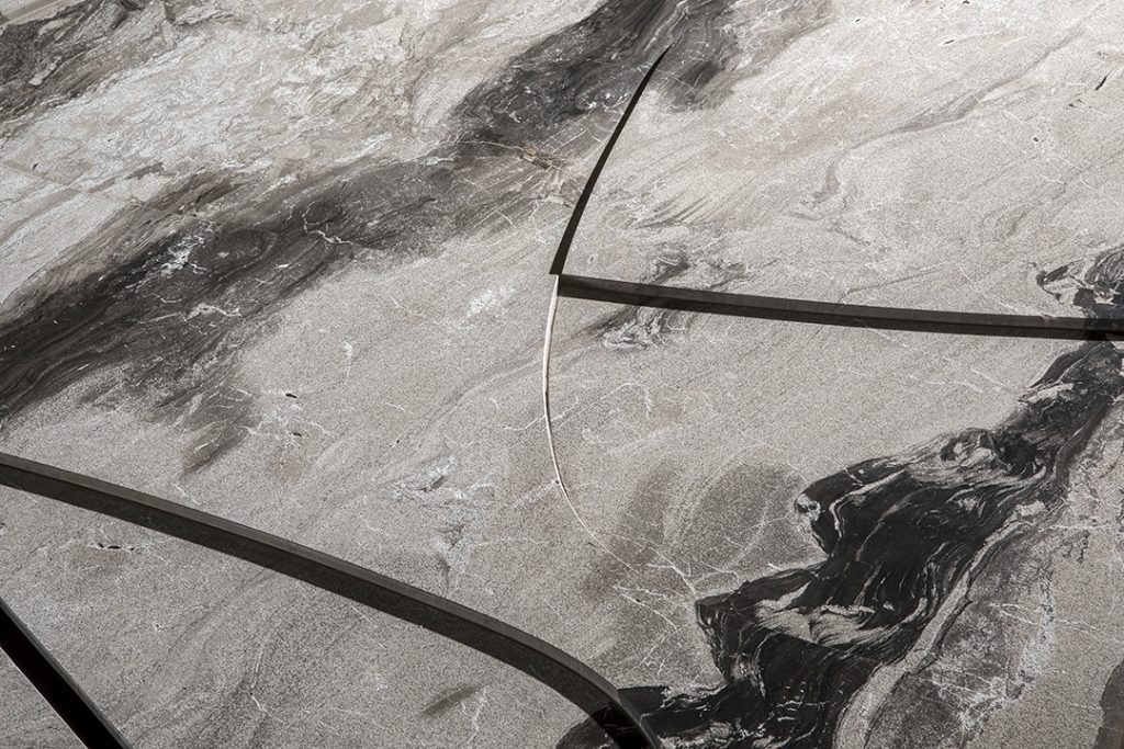 Closeup of Background Coffee Table. White and gray square top and four black legs.