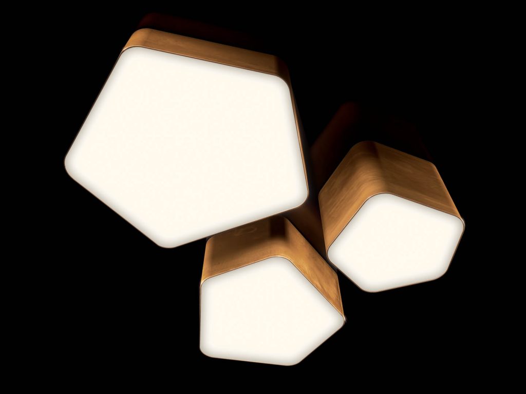 Bat Light LED ceiling lamp with pentagon shapes finished in brass on a black background.