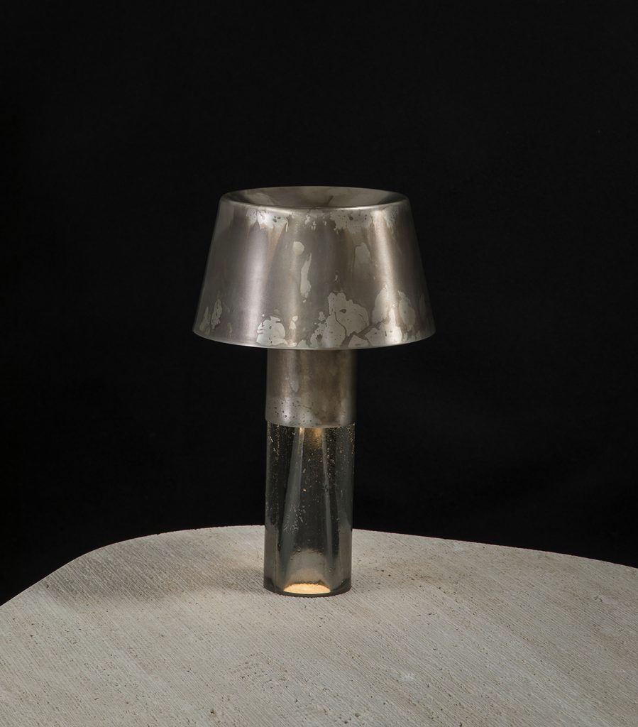 Ghost Lamp Table, central element in resin, light diffuser in steel on a table on a black background.