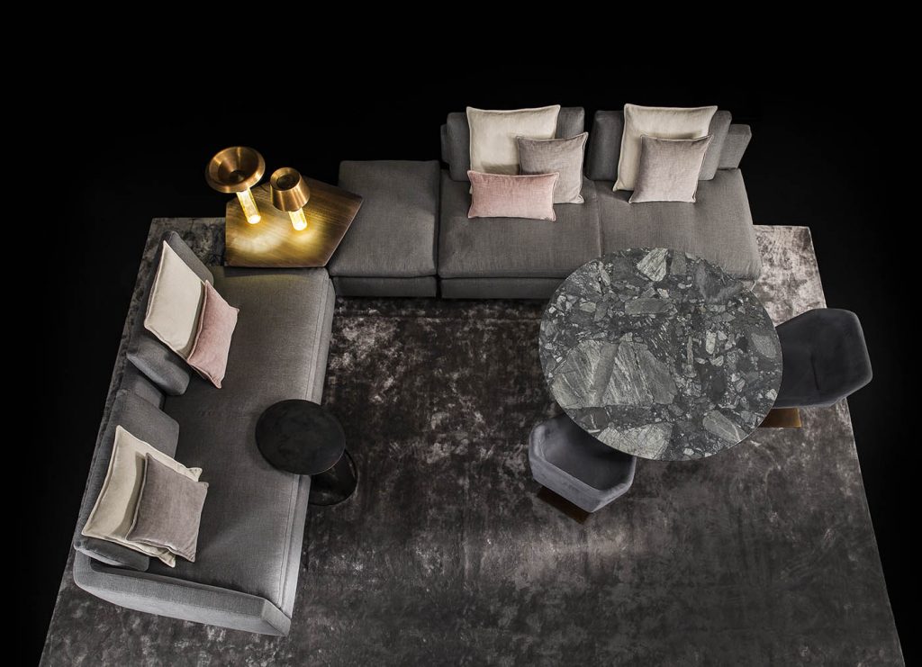 Two Human Sofas with armrest and backrest upholstered in gray fabric with black brass legs in a living room.