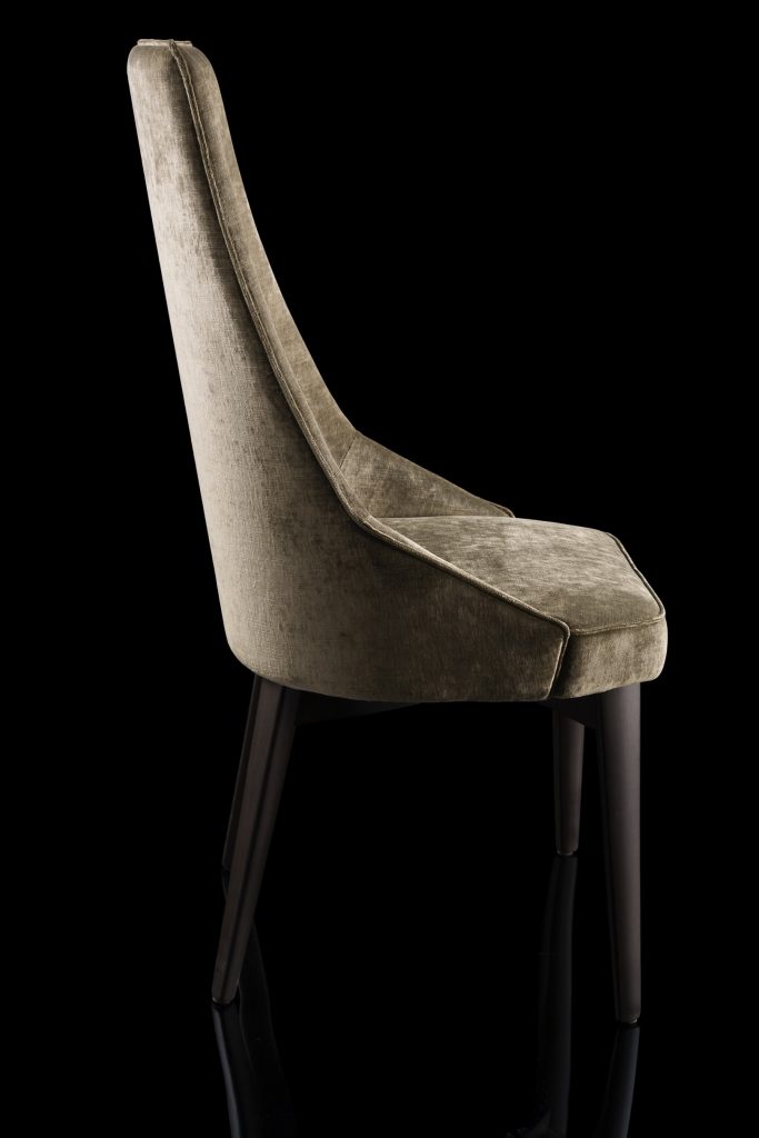 Is A Chair in gray fabric with for legs in black eucalyptus wood on a black background.