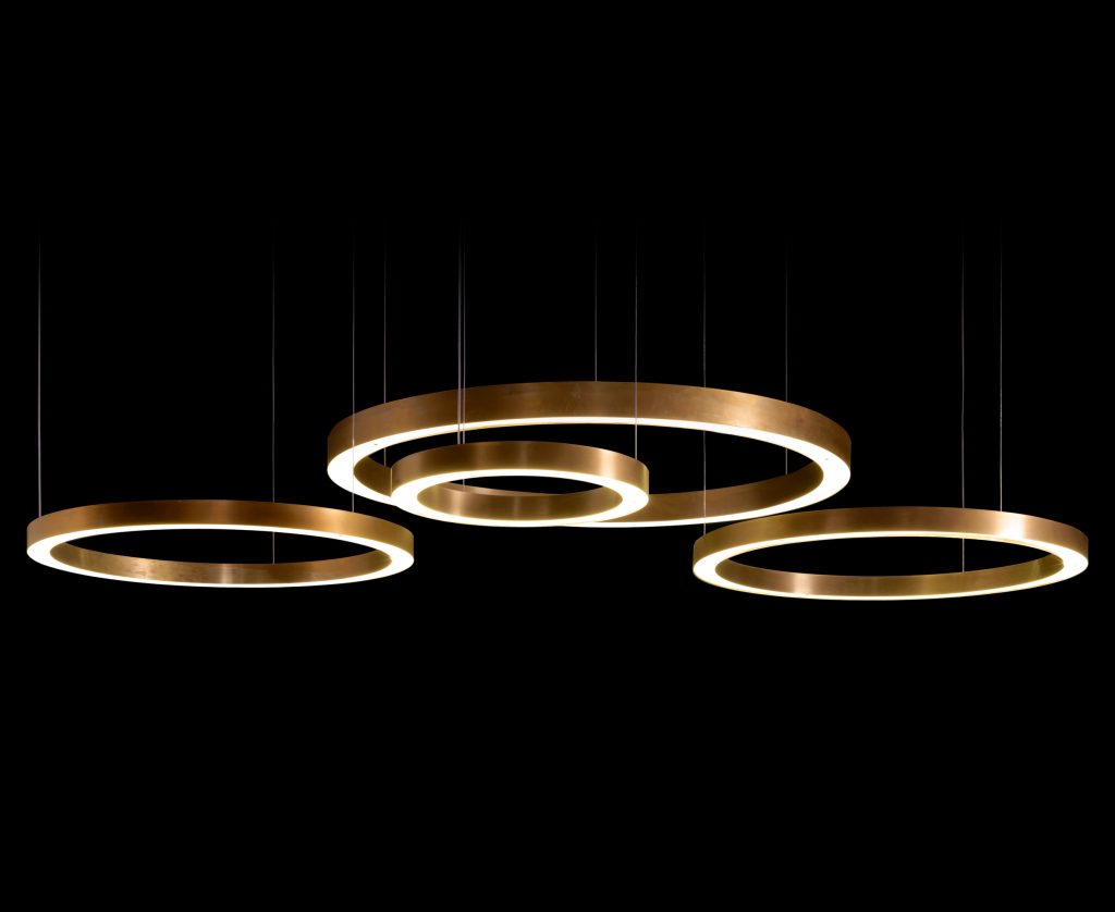 four lamps of different sizes in the shape of rings made of brass in a golden tone