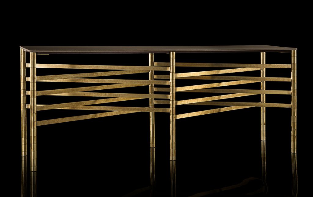 Network Table, top in brown wood, frame made of rectangular brass tubes on a black background.