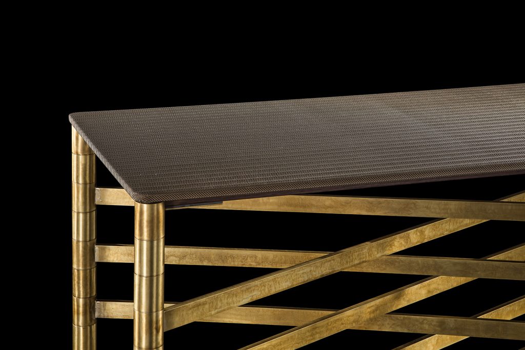 Closeup of Network Table, top in brown wood, frame made of rectangular brass tubes on a black background.