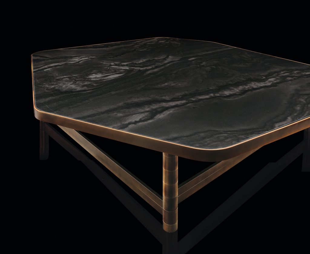 OR Table structure with an irregular polygon shape and four legs in brass tube, top in black wood on a black background.