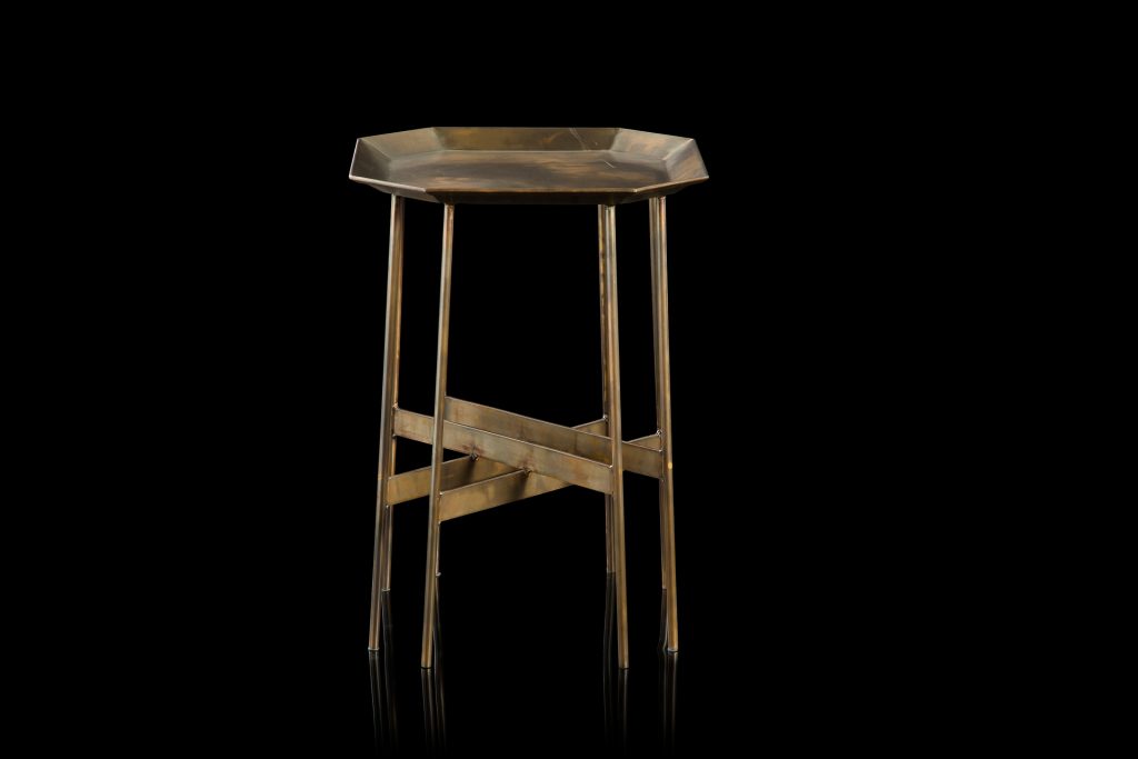 Octagon Table, finish structure and eight legs in burnished brass, tabletop in brass on a black background.