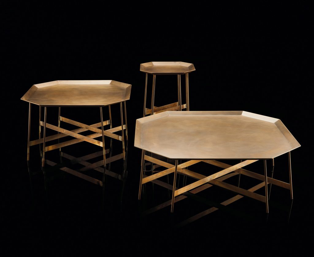 Three Octagon Tables, finish structure and eight legs in burnished brass, tabletops in brass on a black background.
