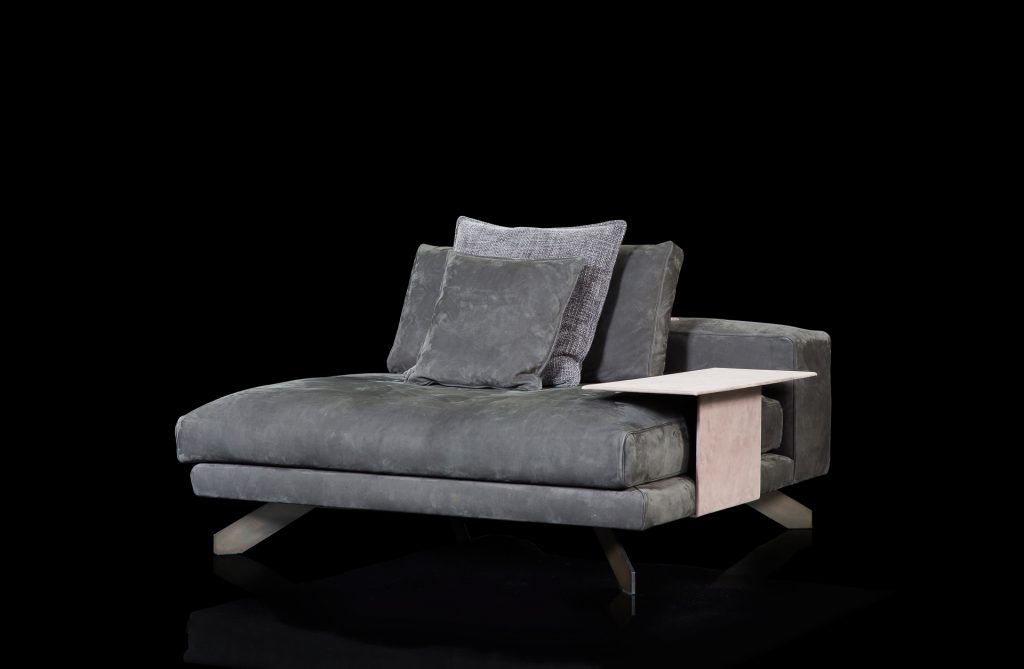 Opus Sofa upholstered in gray fabric with four legs in black steel with gray poufs and a table on a black background.