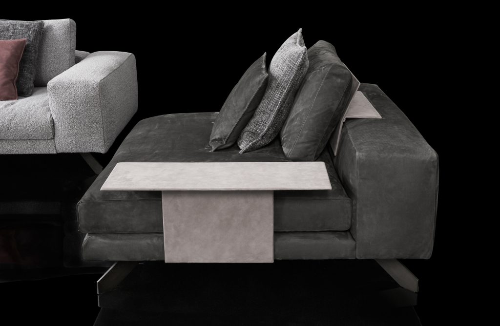 Two Opus Sofas upholstered in gray fabric with four legs in black steel with gray poufs and a table on a black background.