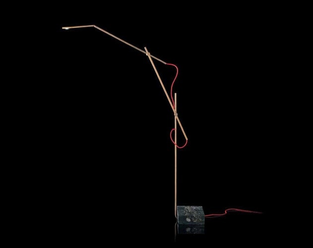 Pipe Light-L. L-shaped bronze lamp with a bulb at the end and red wiring on a black background.