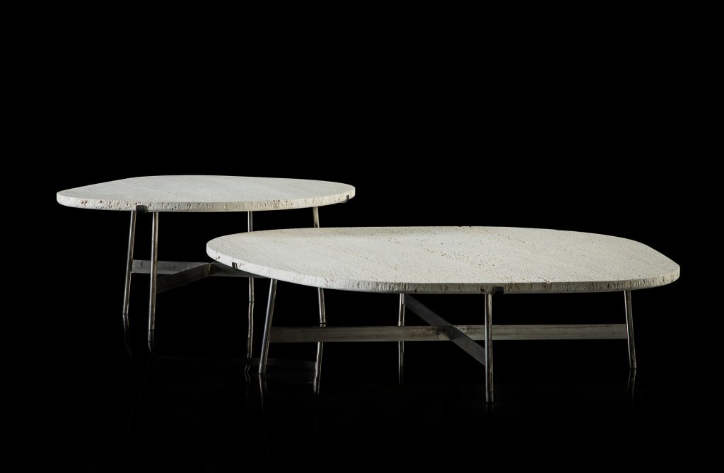 Two round Primitive Tables. Structure leg in metal rod finish burnished titanio. Top in white ostuni stone on a black background.