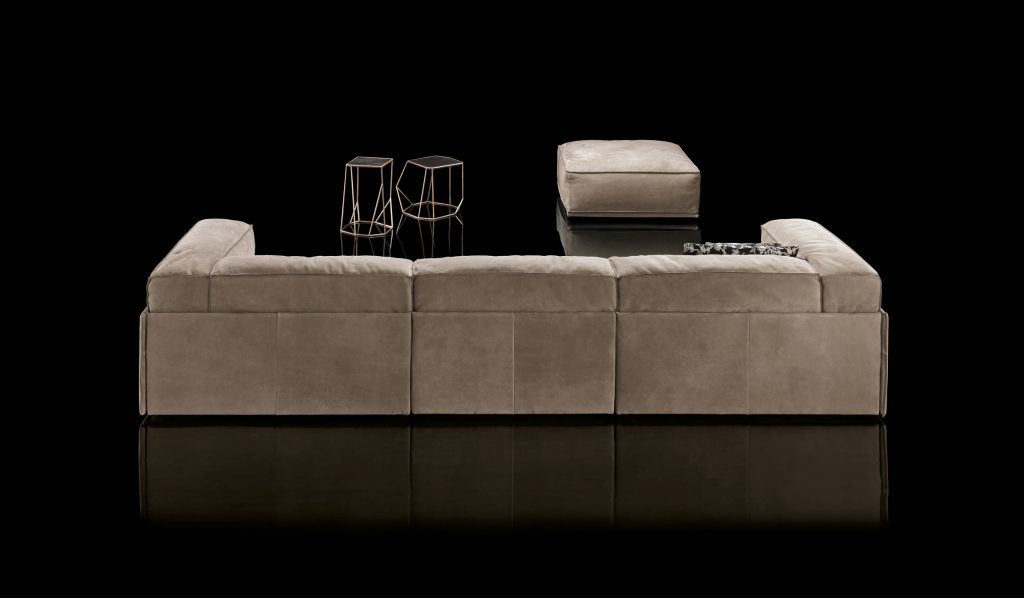 Three seater S-Perla Sofa with backrest and armrest upholstered in brown nappa on a black background.