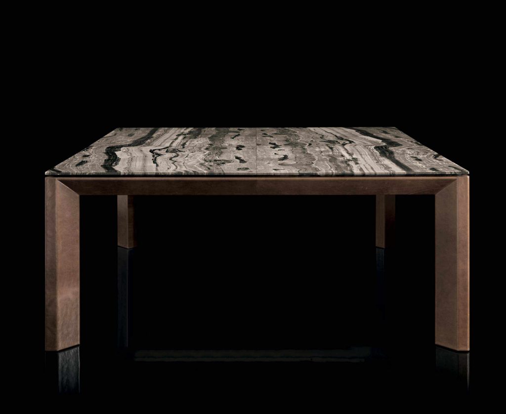 Soprano dining table, structure and four legs in brown wood, top in white, grey, brown and black stone on a black background.