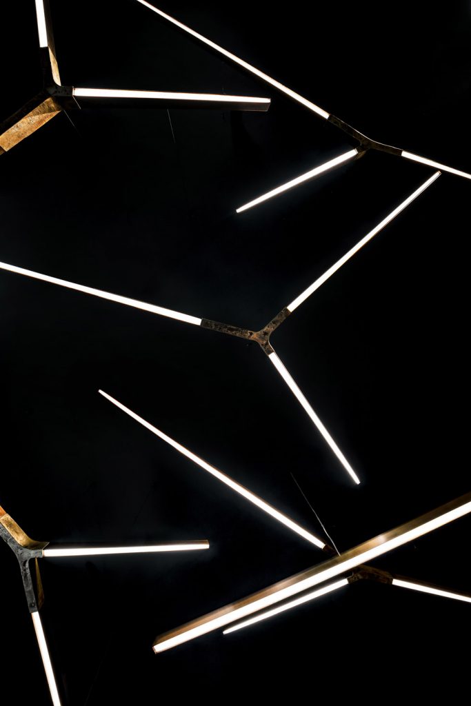 pendant lamp in a golden tone in a shape of geometric lines made of cast bronze
