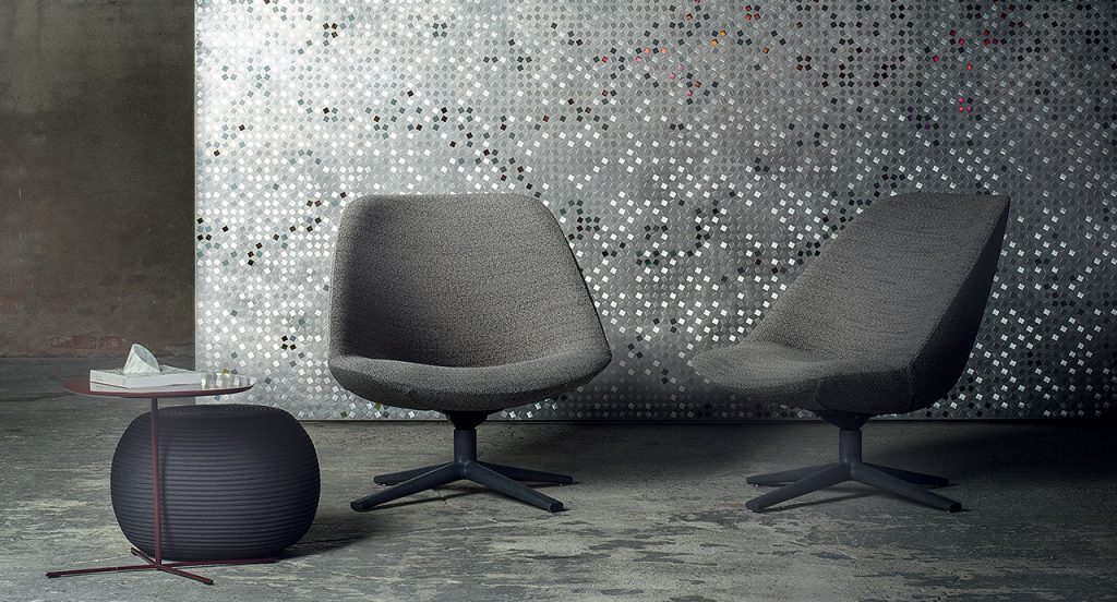 Two Swiveling and tilting Adele Armchairs, gray upholstery cover and black wooden base with four spokes in a living room.