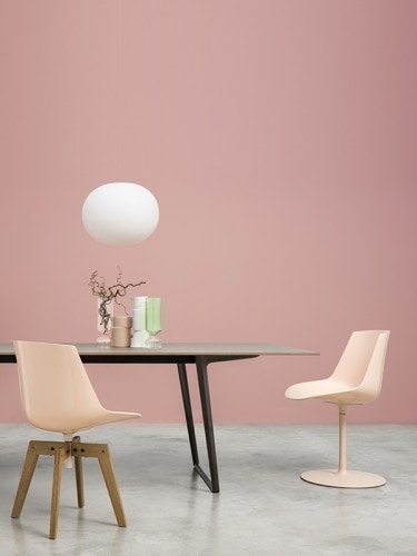 A Axy table, top in white calce and two legs in black aluminium in a dining room.