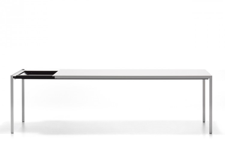 A Extension table, the laminate tabletops and extension tops in Fenix are built-in and are reinforced internally by thick aluminium sheets with four legs in aluminium on a white background.