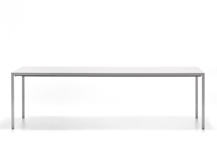 A Extension table, the laminate tabletops and extension tops in Fenix are built-in and are reinforced internally by thick aluminium sheets with four legs in aluminium on a white background.