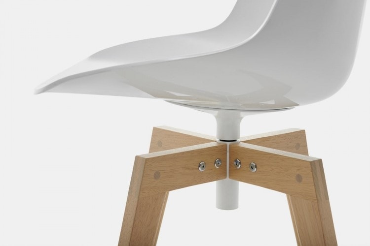 A white Flow Chair Iroko with four-legged in natural oak on a white room background.