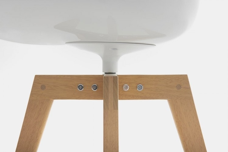 A white Flow Chair Iroko with four-legged in natural oak on a white room background.