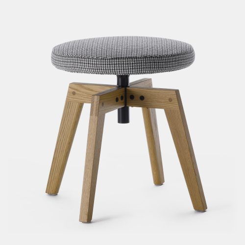 A white and black pattern flow pouf with a natural wooden bottom on a white room background.