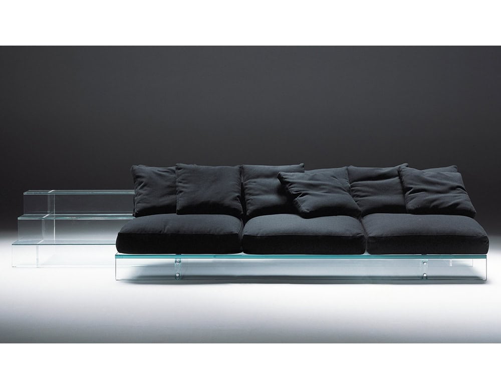 Simplicity Sofa features a modern glass base with plush, deep black cushions, blending contemporary design with luxurious comfort