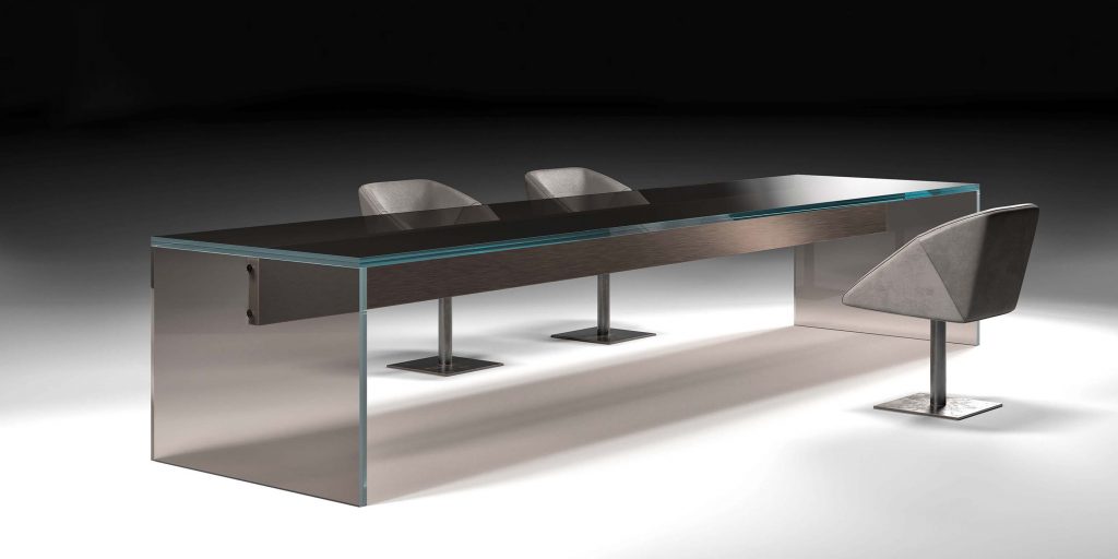 A modern glass conference table with a sleek, reflective surface and minimalist design. The table features a long, spacious top supported by transparent legs