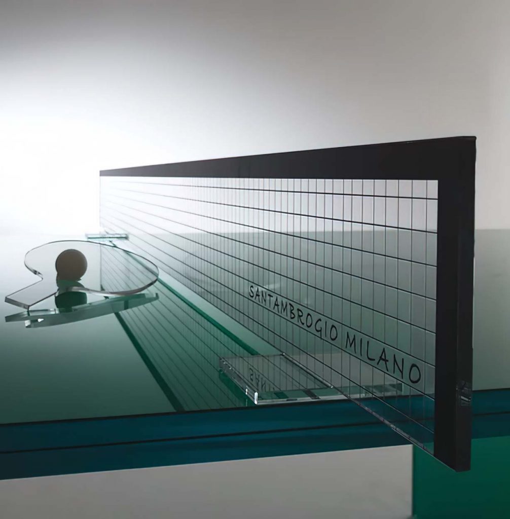 Sleek modern glass table with a transparent green-tinted surface and black metal frame, showcasing a minimalist design with sharp angles and clean lines