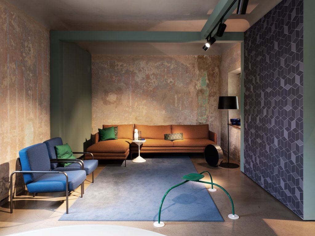 Allunaggio stool with a round green seat and three metal legs in a living room.