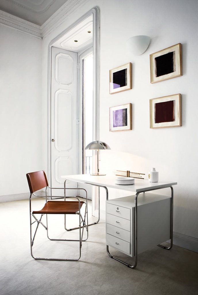 Folding chair. Back and seat in brown leather. Silver metal structure in an office.