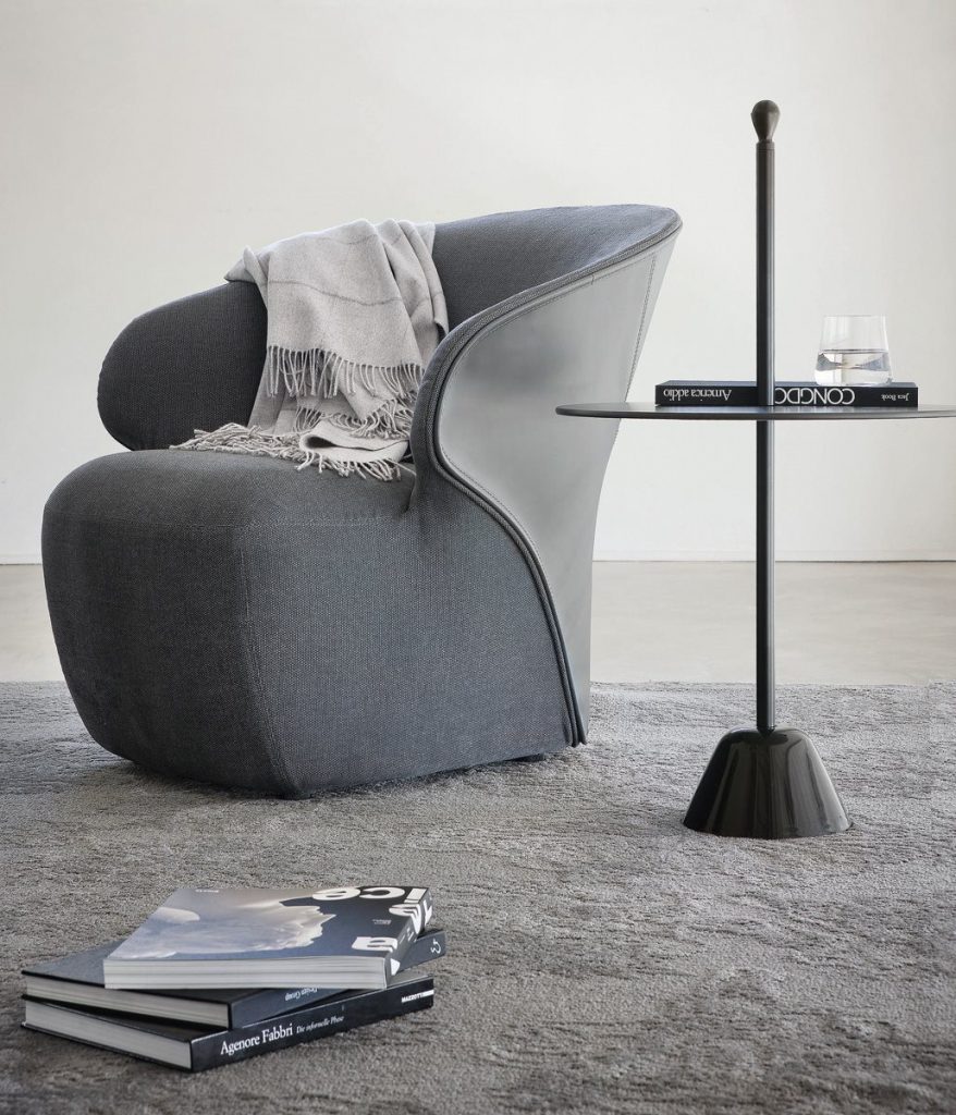 Arom armchair upholstered in two shades of gray fabric in a living room.