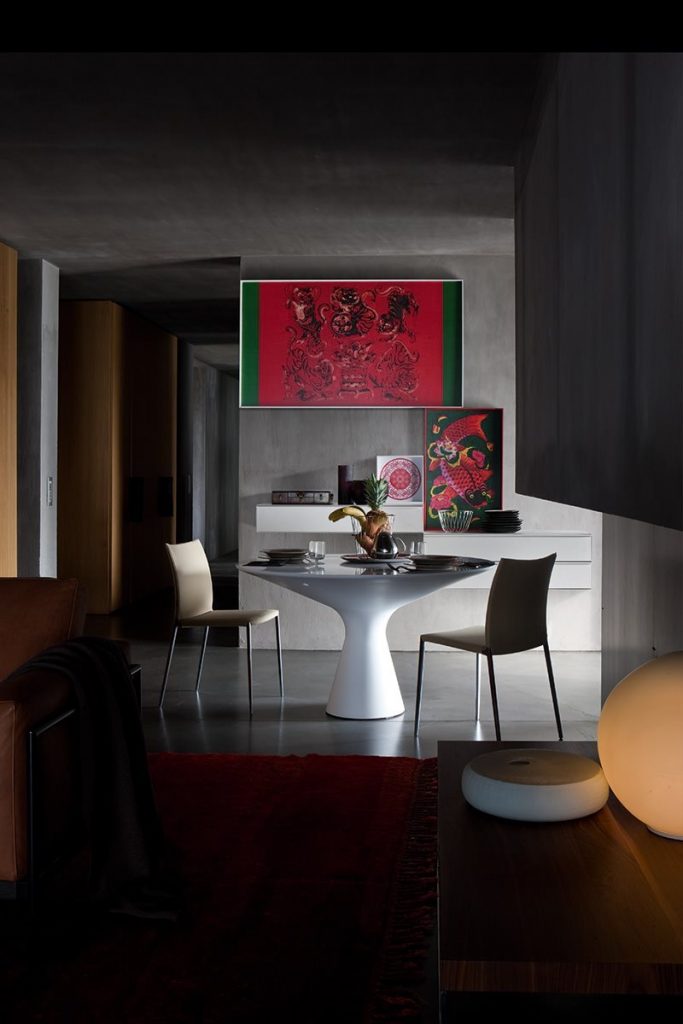Blanco table with a round white top and wooden legs in a room in a dining room.