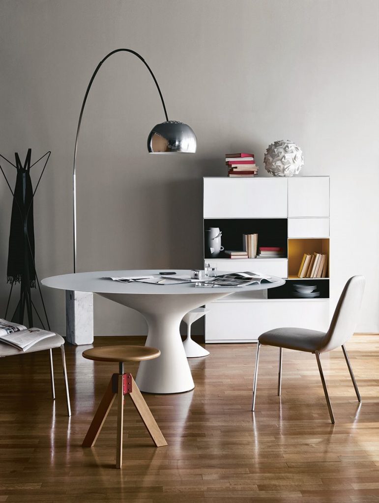 Blanco table with a round white top and wooden legs in a room in a dining room.