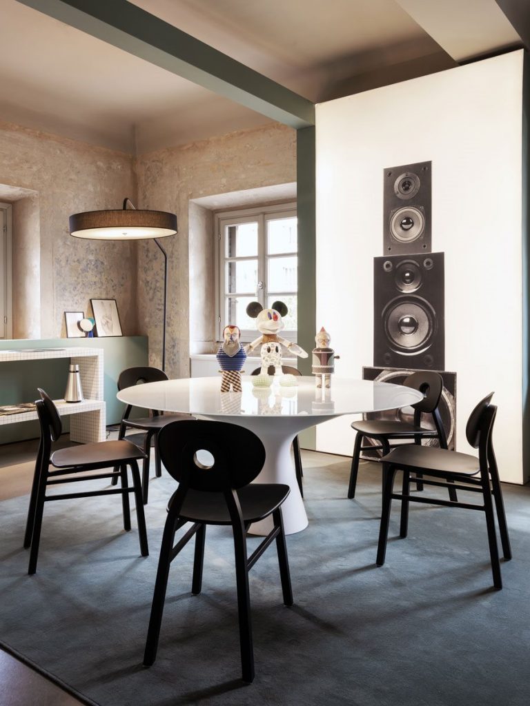 Blanco table with a round white top and wooden legs in a room in a dining room.