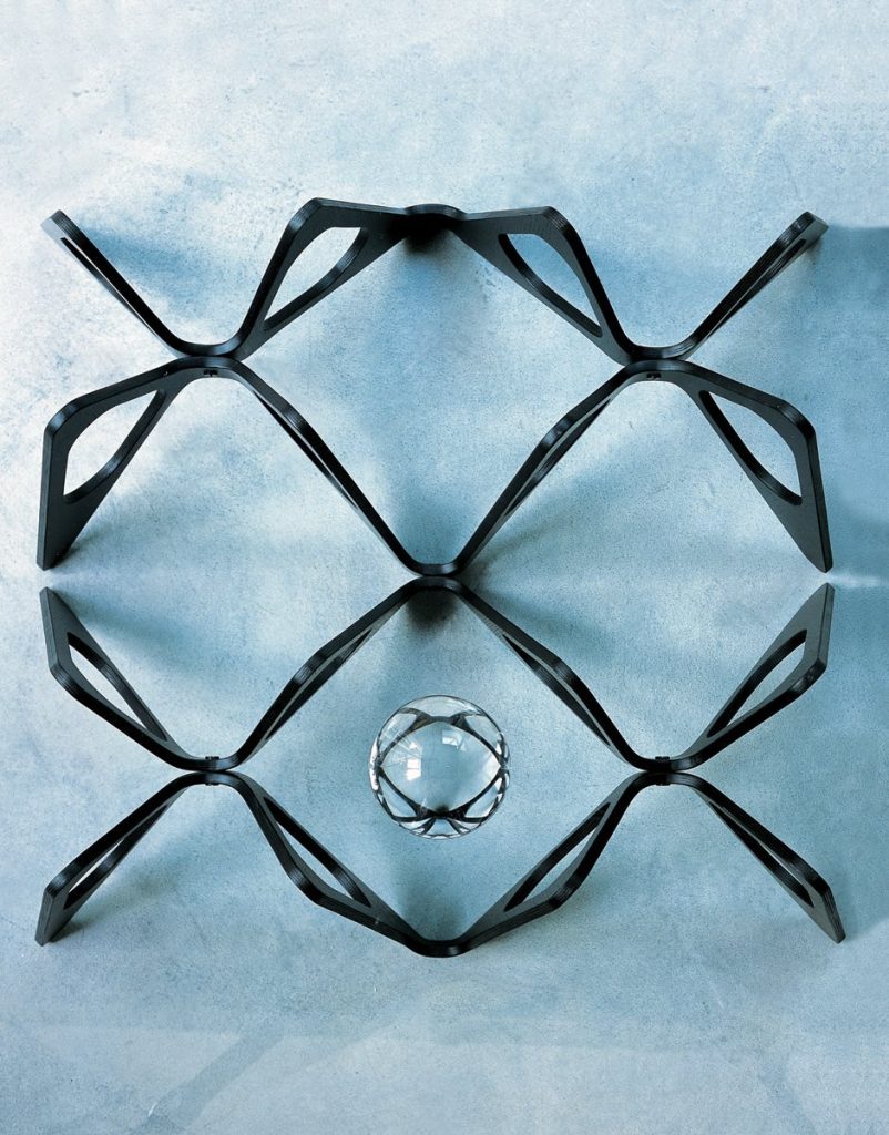 Butterfly coffee table. Top in transparent glass and base en black with butterfly like pattern on a blue background.