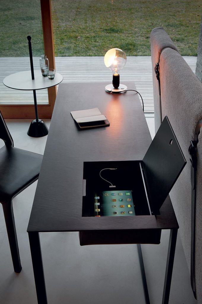 Rectangular Calamo desk, top in black and structure with two legs in black in an office.