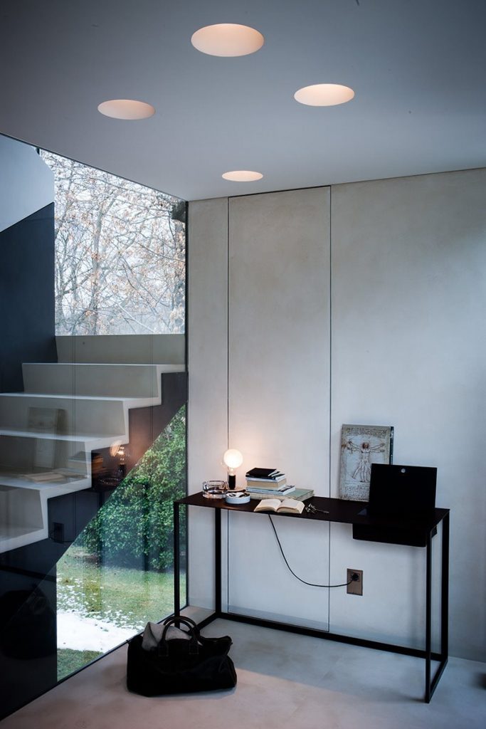Rectangular Calamo desk, top in black and structure with two legs in black in an office.