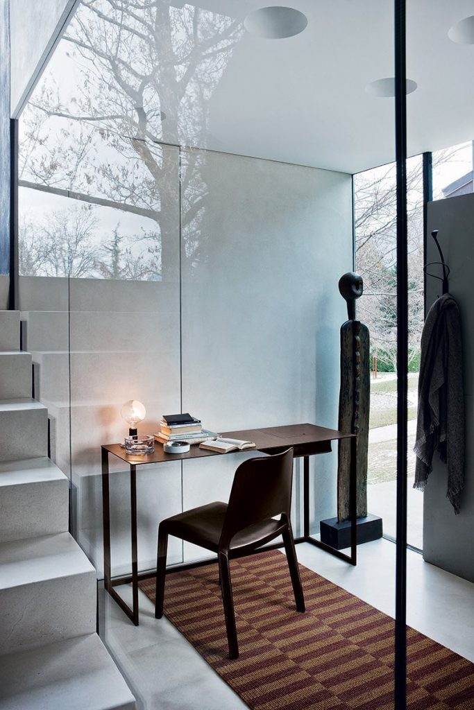Rectangular Calamo desk, top in brown and structure with two legs in black in an office.