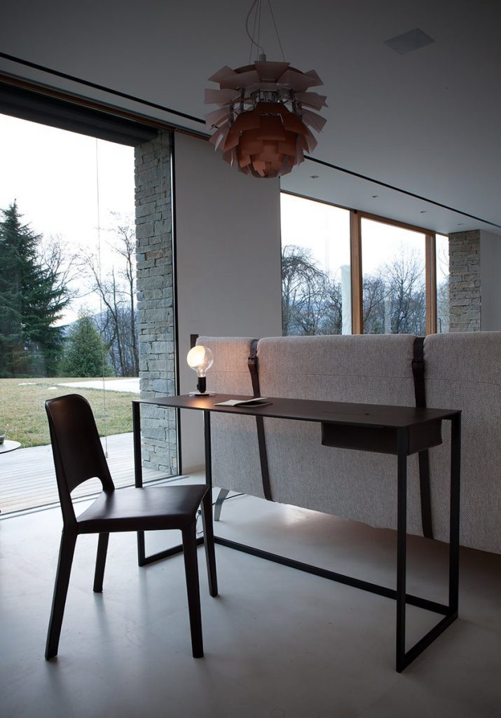 Rectangular Calamo desk, top in brown and structure with two legs in black in an office.