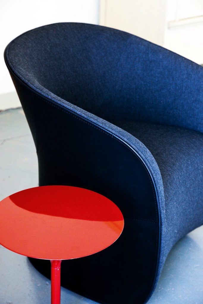 Calla armchair upholstered in blue fabric on a gray background.