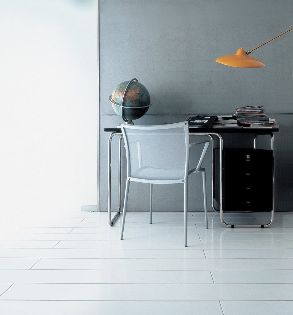 Comacina desk with a rectangle black top, black drawers and metal legs in an office.