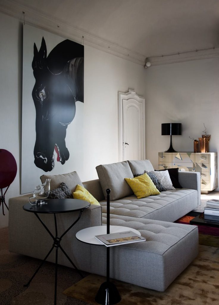 Cumano black side table with a minimalist design, featuring a round top and a slender metal base in a living room.