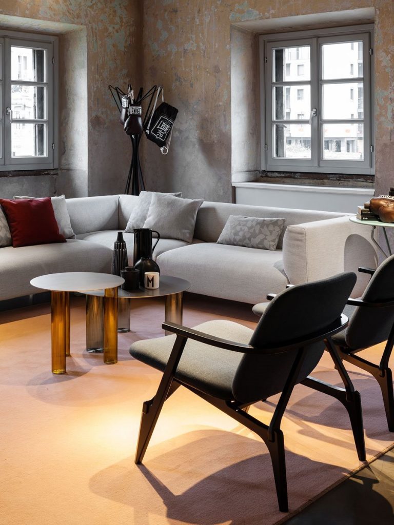 Two Echino coffee table. Round gray top and three semi transparent cilindrical legs in bronze in a living room.